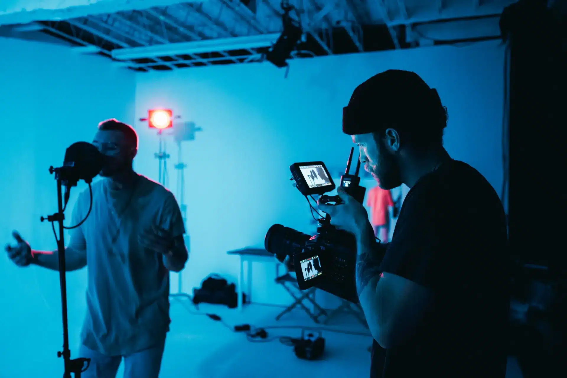 Filmmaker operating a camera during a marketing video production shoot in a studio